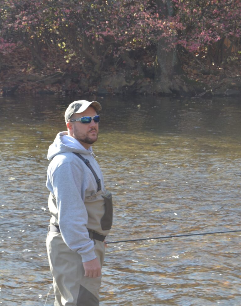 a man standing in the water with a fishing rod
