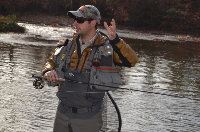 a man standing in the water holding a fishing rod