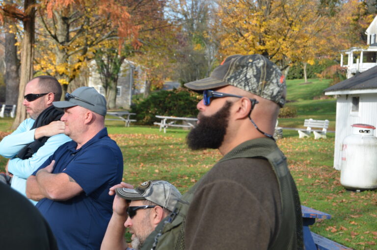 a group of men sitting on top of a blue bench
