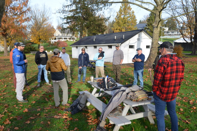 a group of men standing around a picnic table