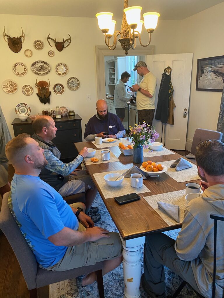 a group of men sitting around a table eating food