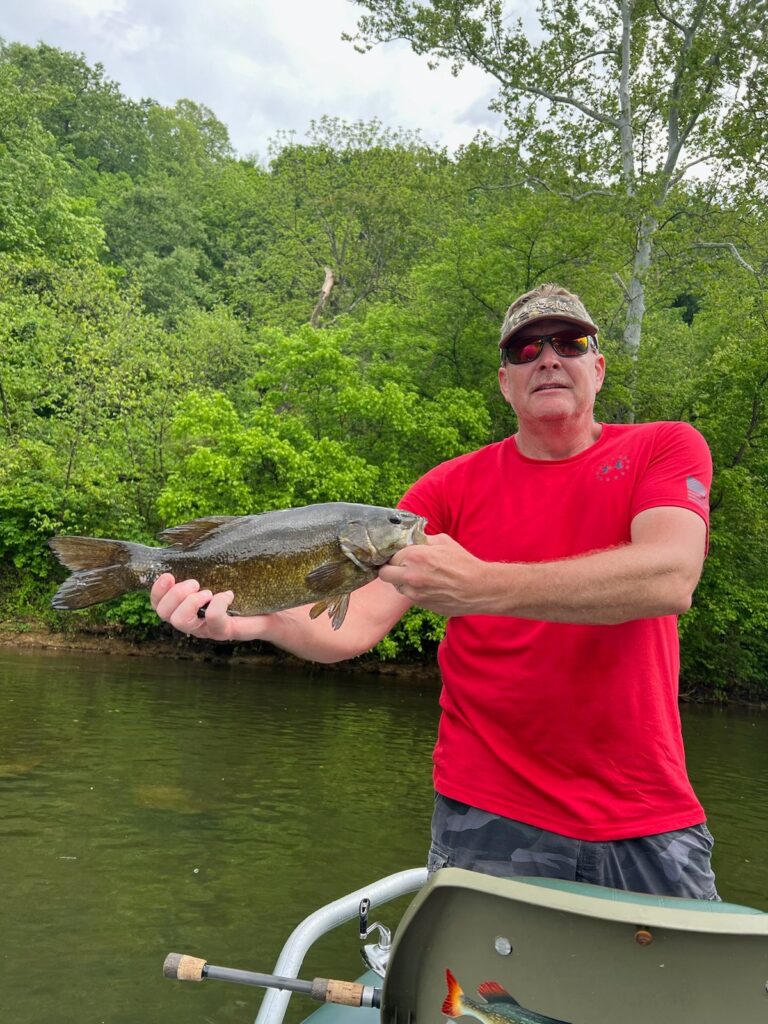a man in a red shirt holding a fish