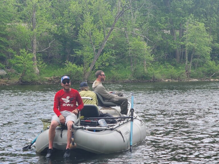 three people are sitting on an inflatable boat