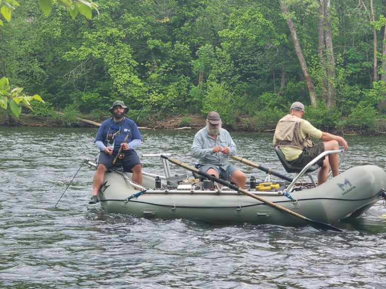 three men in a boat on a river