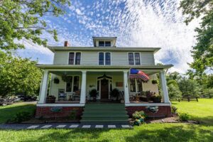 a white house with an american flag on the front porch