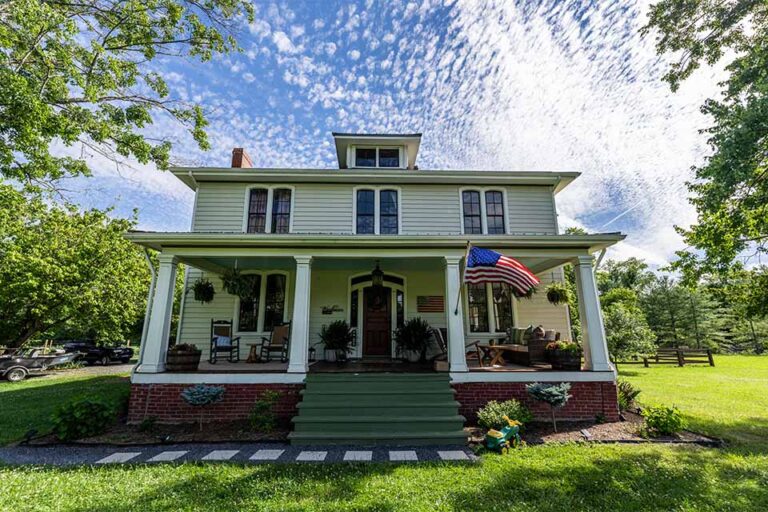 a white house with an american flag on the front porch