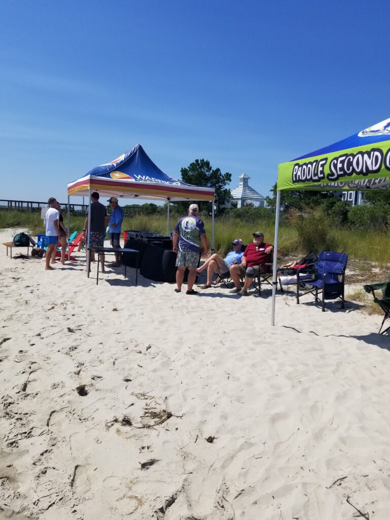 a group of people standing on top of a sandy beach
