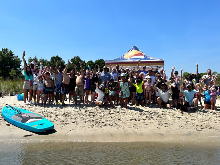a group of people standing on top of a sandy beach