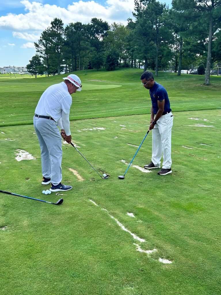 two men playing golf on a green field