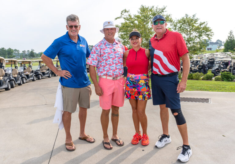 three people standing next to each other in front of golf carts