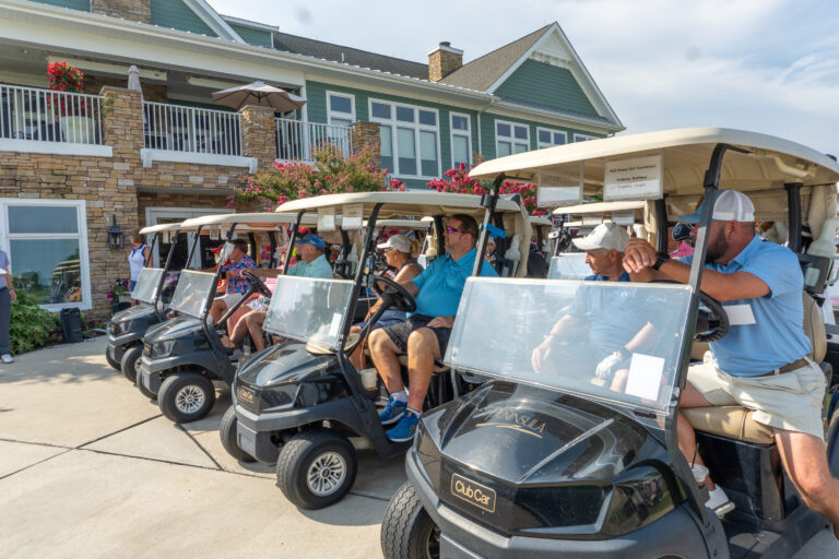 a group of people riding on the back of golf carts