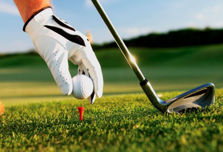a man putting a golf ball in the hole