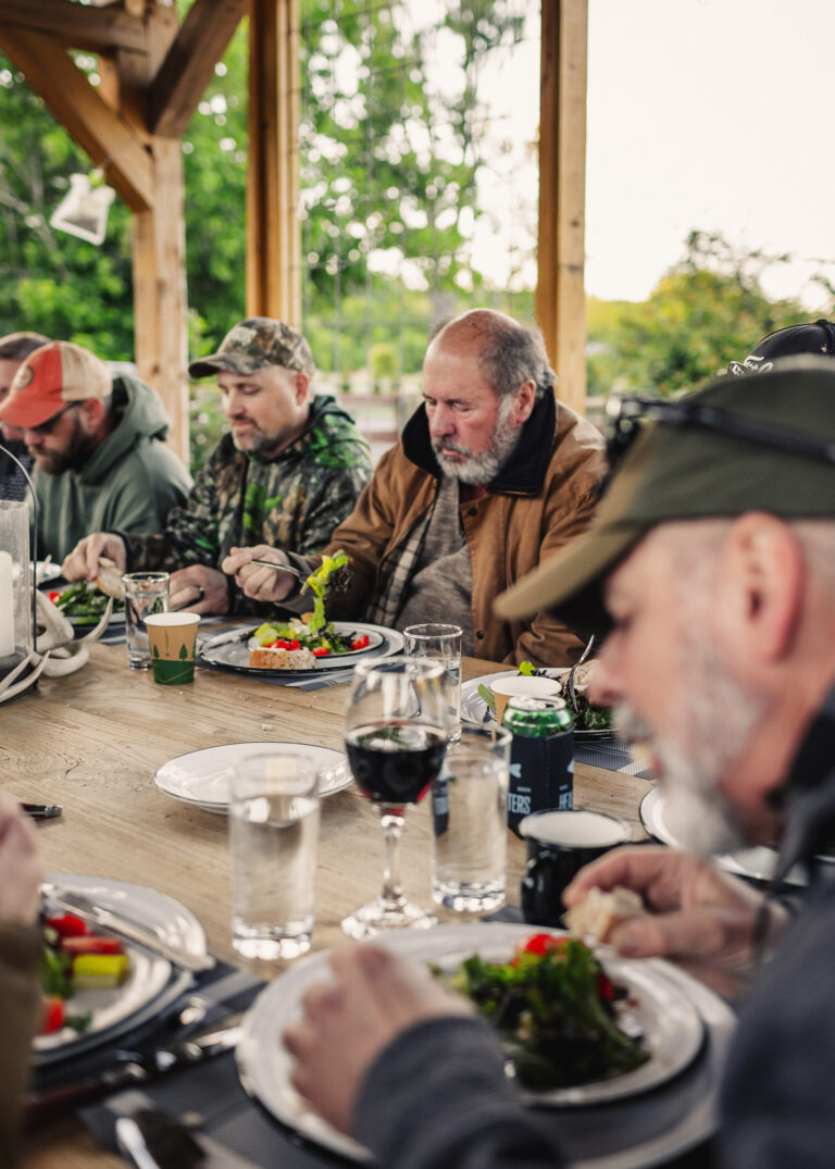 a group of men sitting around a table eating food