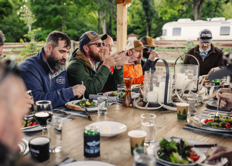 a group of people sitting around a wooden table