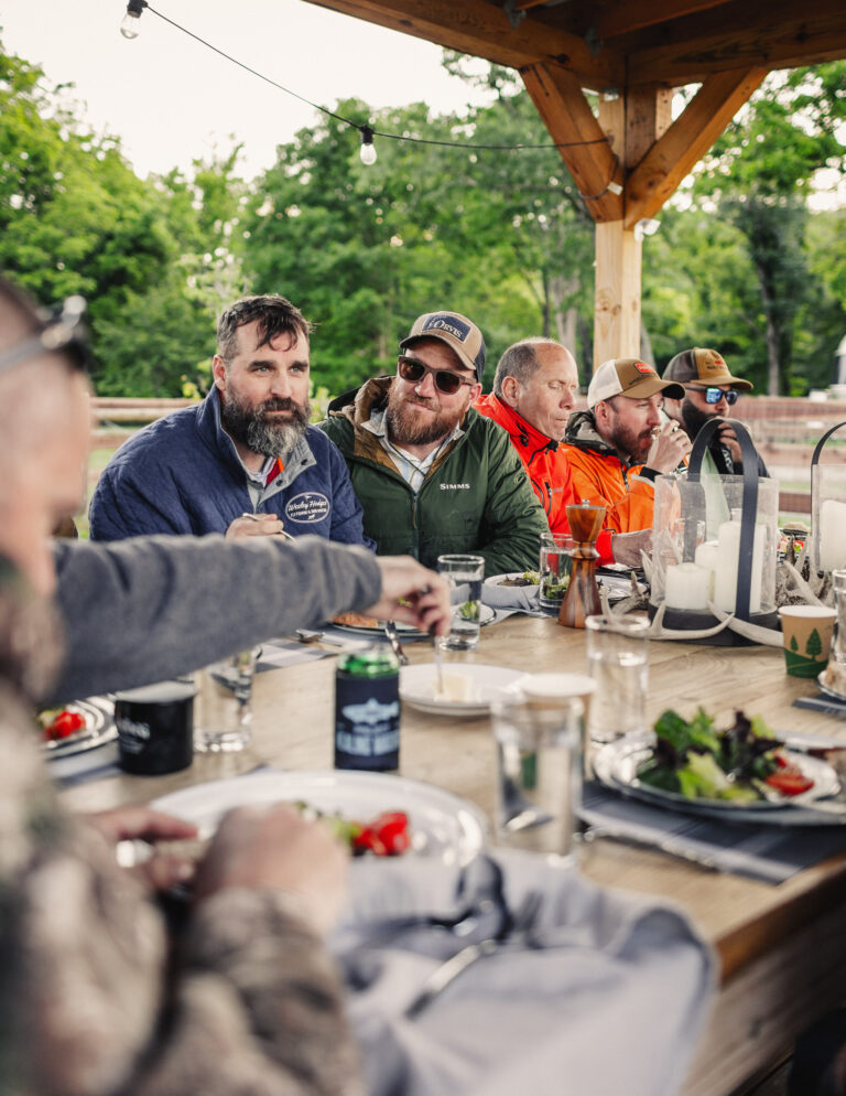 a group of men sitting around a table eating food