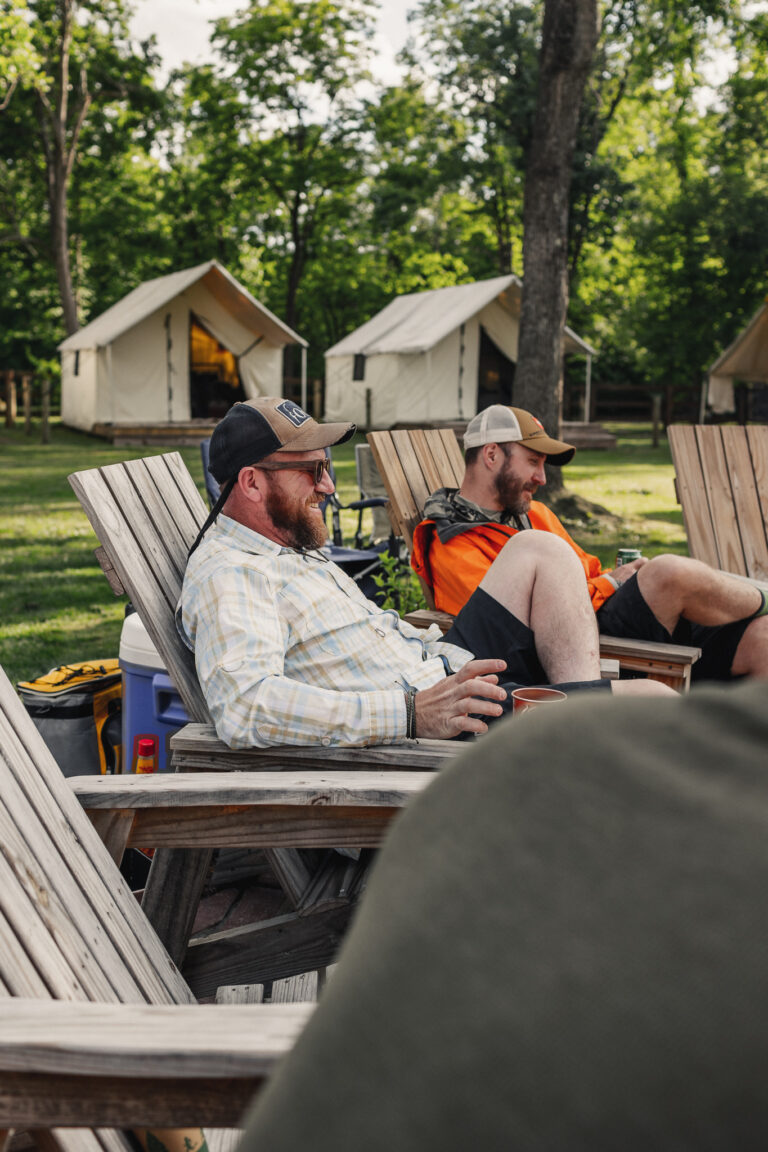 a couple of men sitting on top of wooden chairs