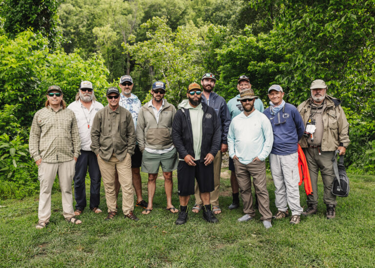 a group of men standing on top of a lush green field