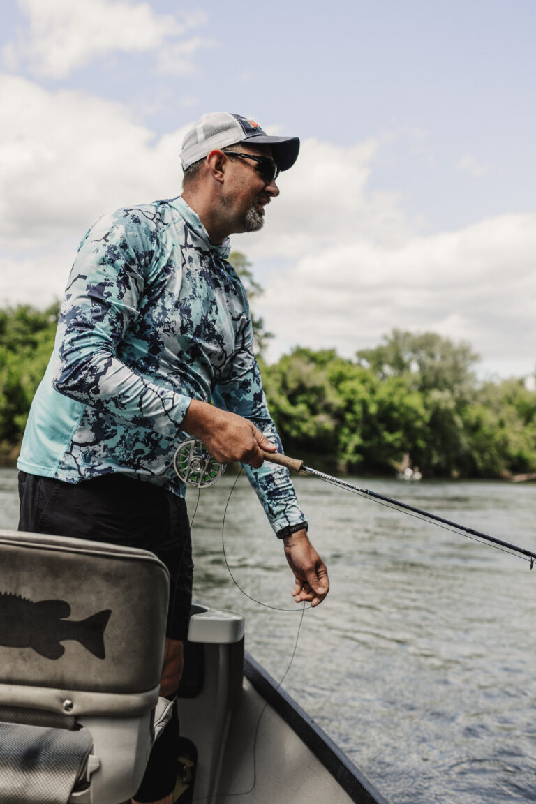 a man fishing on a boat in the water