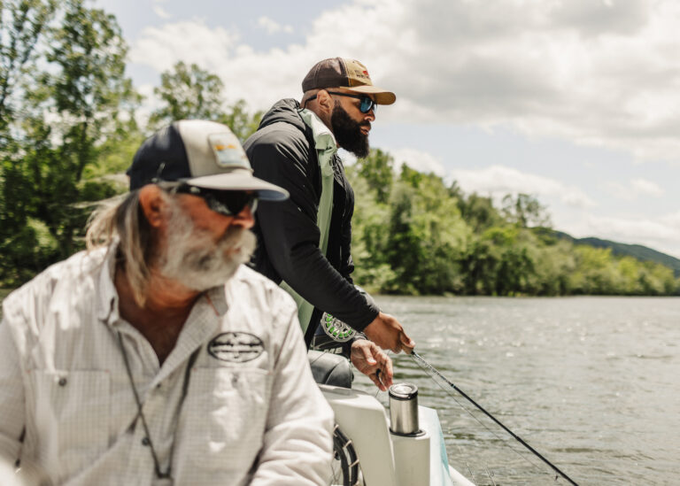 two men on a boat fishing on a lake
