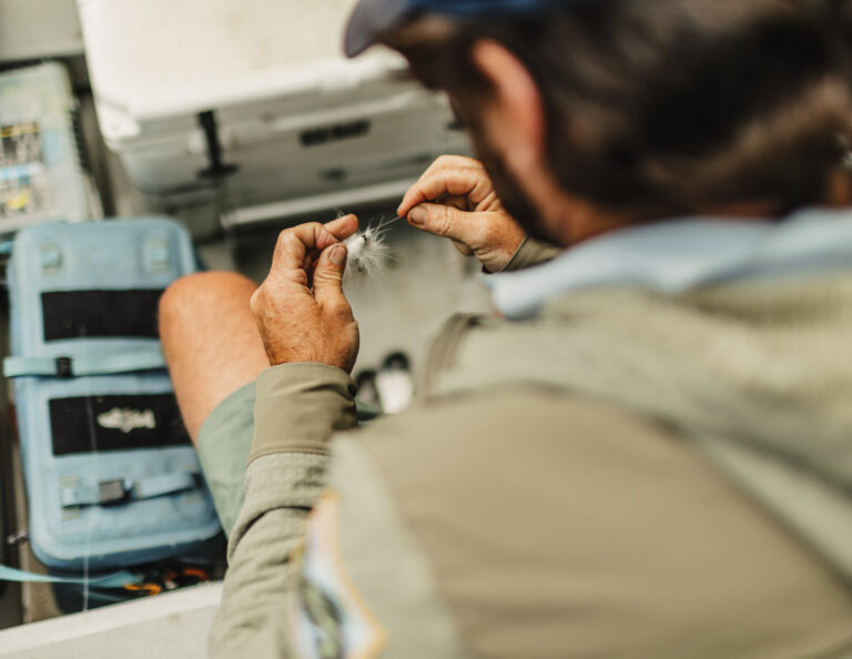 a man sitting on a boat looking at his cell phone