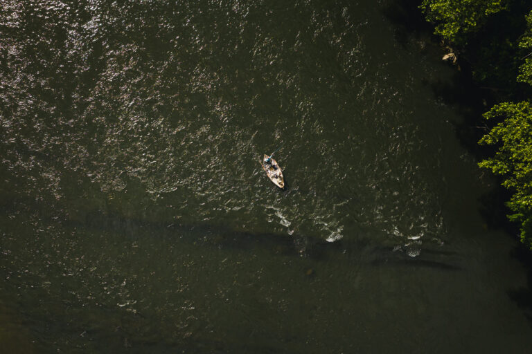 an aerial view of a boat on a river