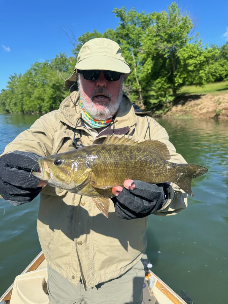 a man in a boat holding a fish