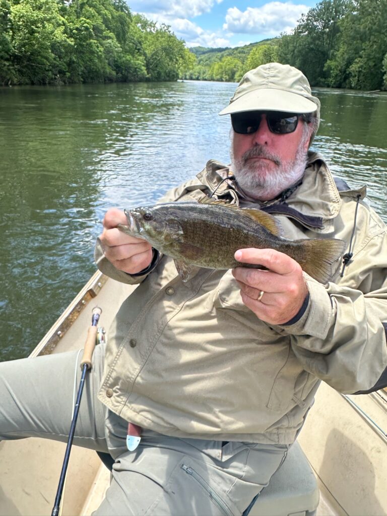 a man on a boat holding a fish