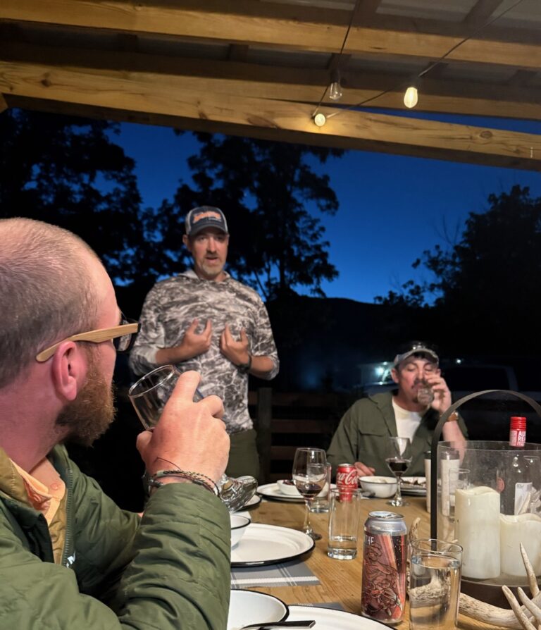 a group of men sitting around a table eating food