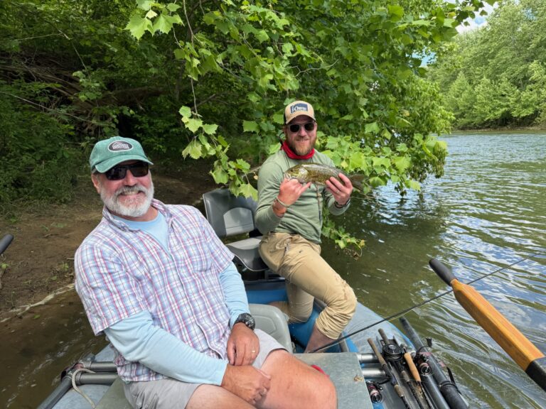 a couple of men sitting on top of a boat
