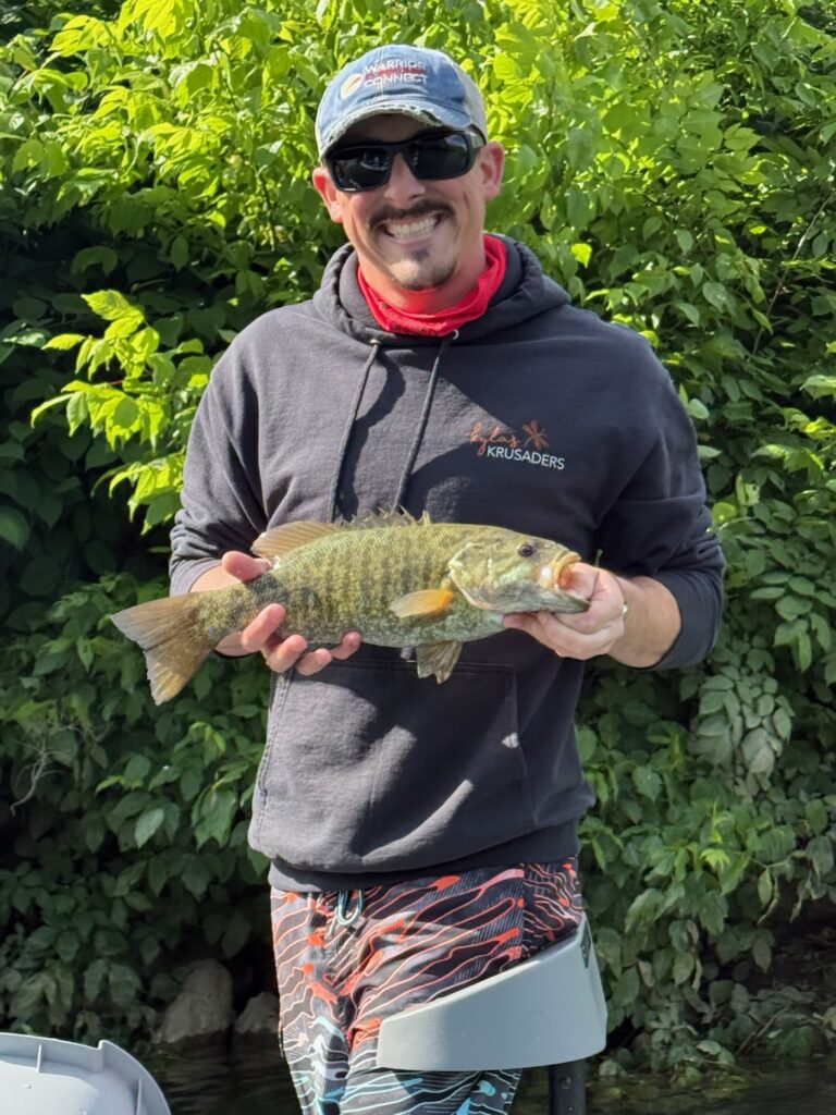 a man standing on a boat holding a fish