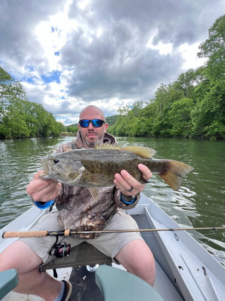 a man in a boat holding a fish