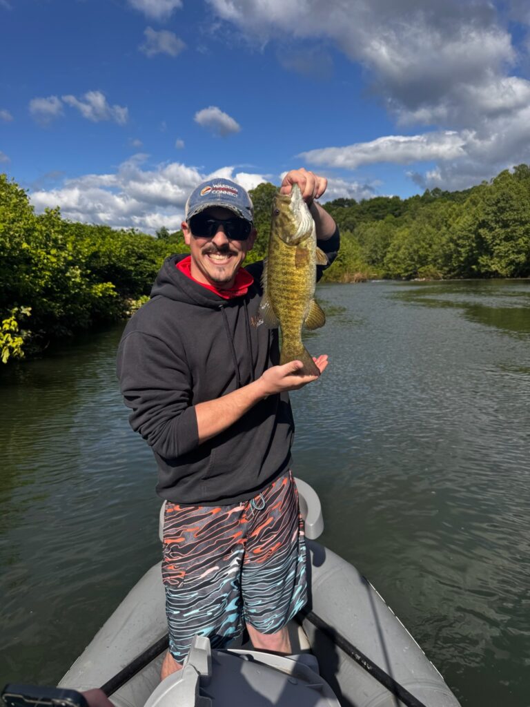 a man on a boat holding a fish