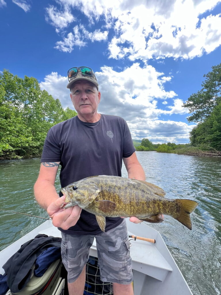 a man on a boat holding a large fish