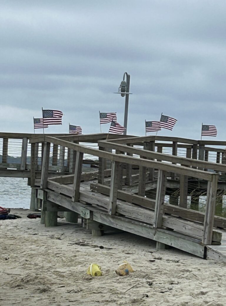 a wooden pier with american flags on top of it