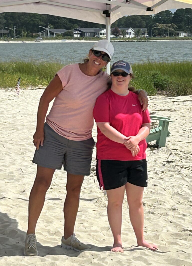 a couple of women standing next to each other on a beach