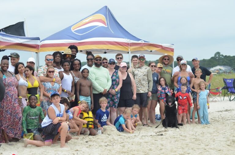 a group of people standing on top of a sandy beach