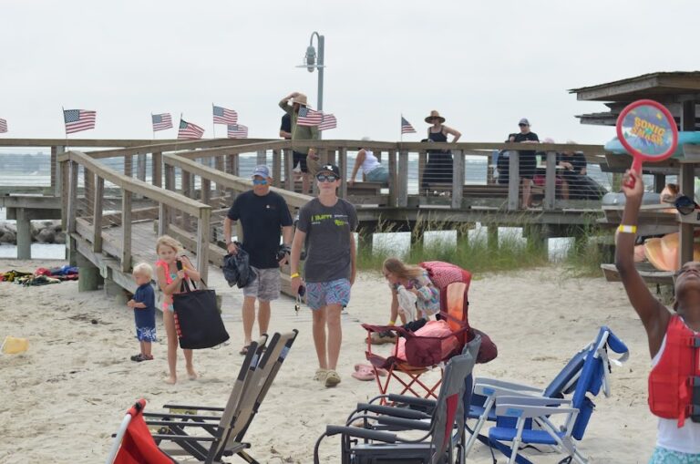 a group of people standing on top of a sandy beach