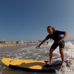 girl smiling as she rides in a wave on her surfboard