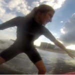 close up of girl standing on surfboard