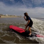 girl standing on surfboard in shallow water