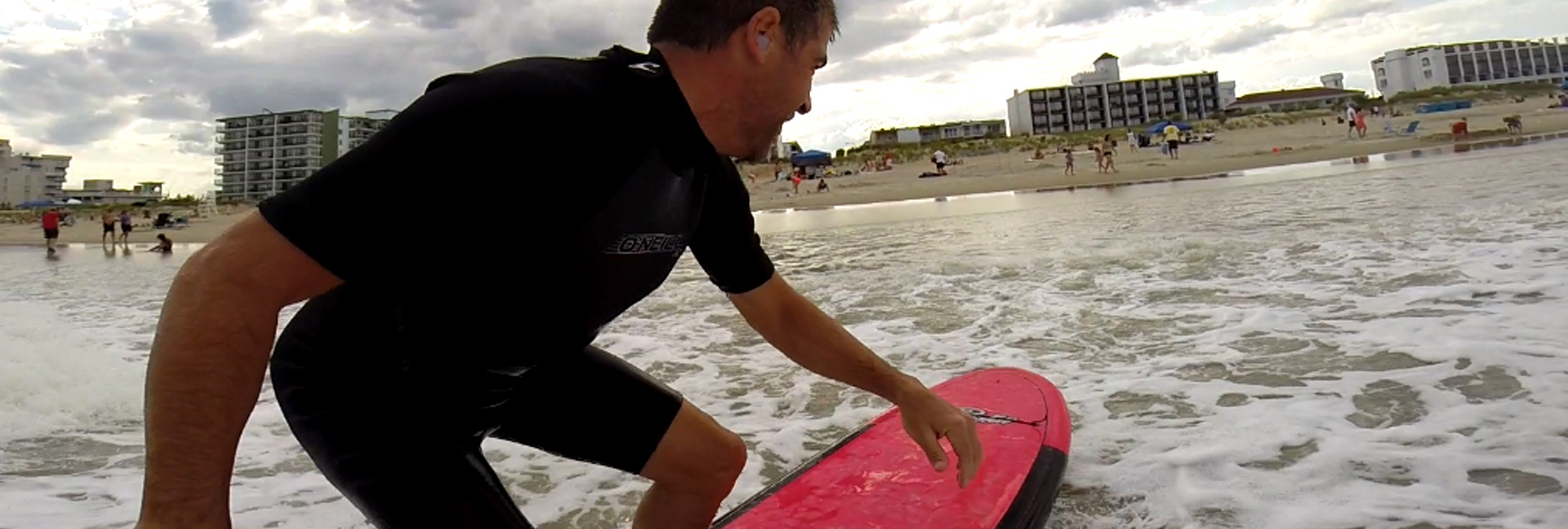 view of the beach from the surfer's POV on the board in the water
