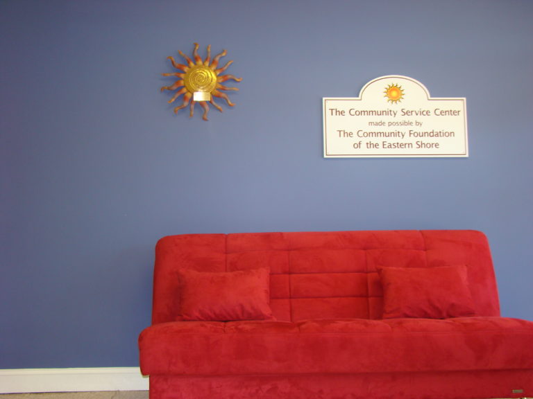 plush comfortable red couch along the Ray wall