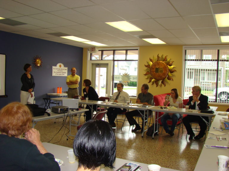 meeting of adults sitting at U shaped folding tables