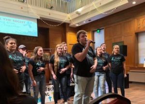 Choral group singing and wearing "Take Back the Night" shirts