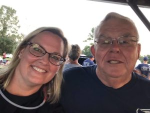 Woman and gentleman smile for camera at outdoor event