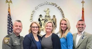 Wicomico leaders pose in front of State's Attorney office seal and flags