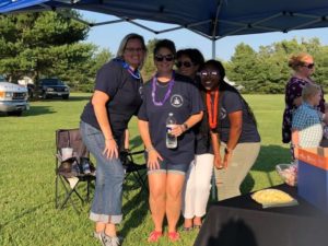 Staff posing together under National Night Out booth tent