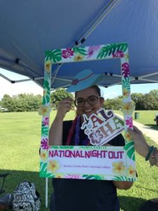 Woman posing with cutout frame with tropical theme