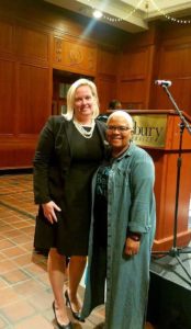 Jamie L. Dykes and Take Back the Night attendee posing in front of stage and podium