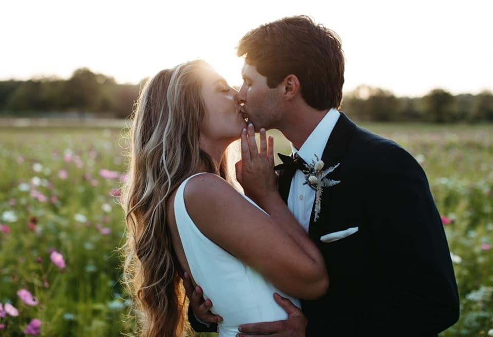 bride and groom kissing in the vineyard at Windmill Creek